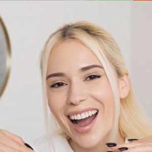 Mujer sonriendo con la boca abierta después de enjuagarse al retirar las tiras blanqueadoras