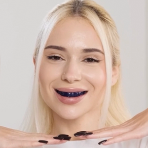 Mujer sonriendo con las tiras blanqueadoras moradas modosmile puestas durante la sesión de 30 minutos