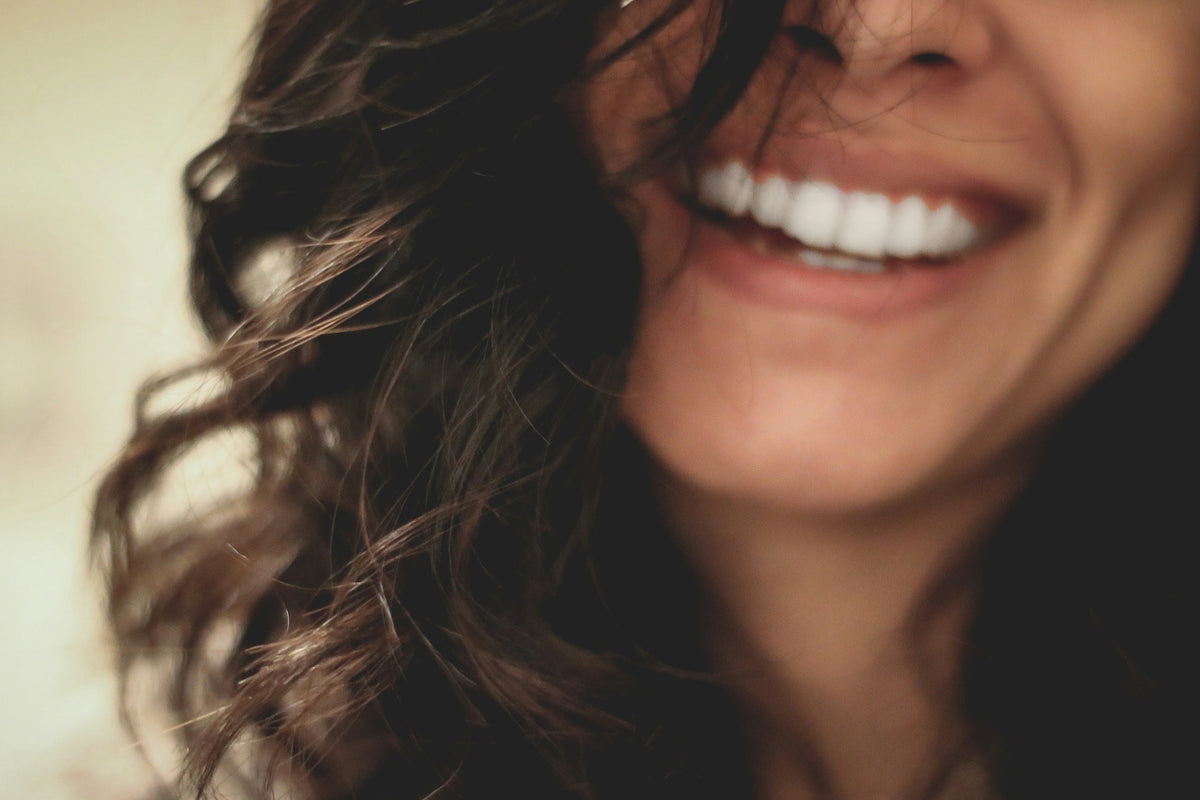 Primer plano de una mujer sonriendo con los dientes blancos