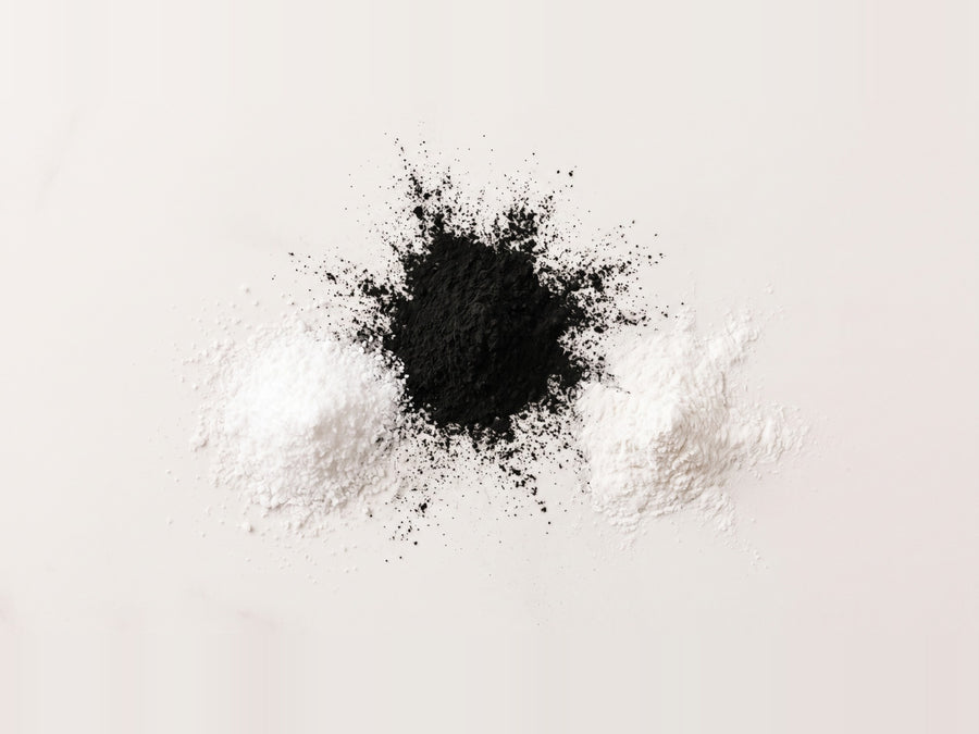 Tres montones de polvo, blanco, negro y blanco: sílice, carbón activado y bicarbonato