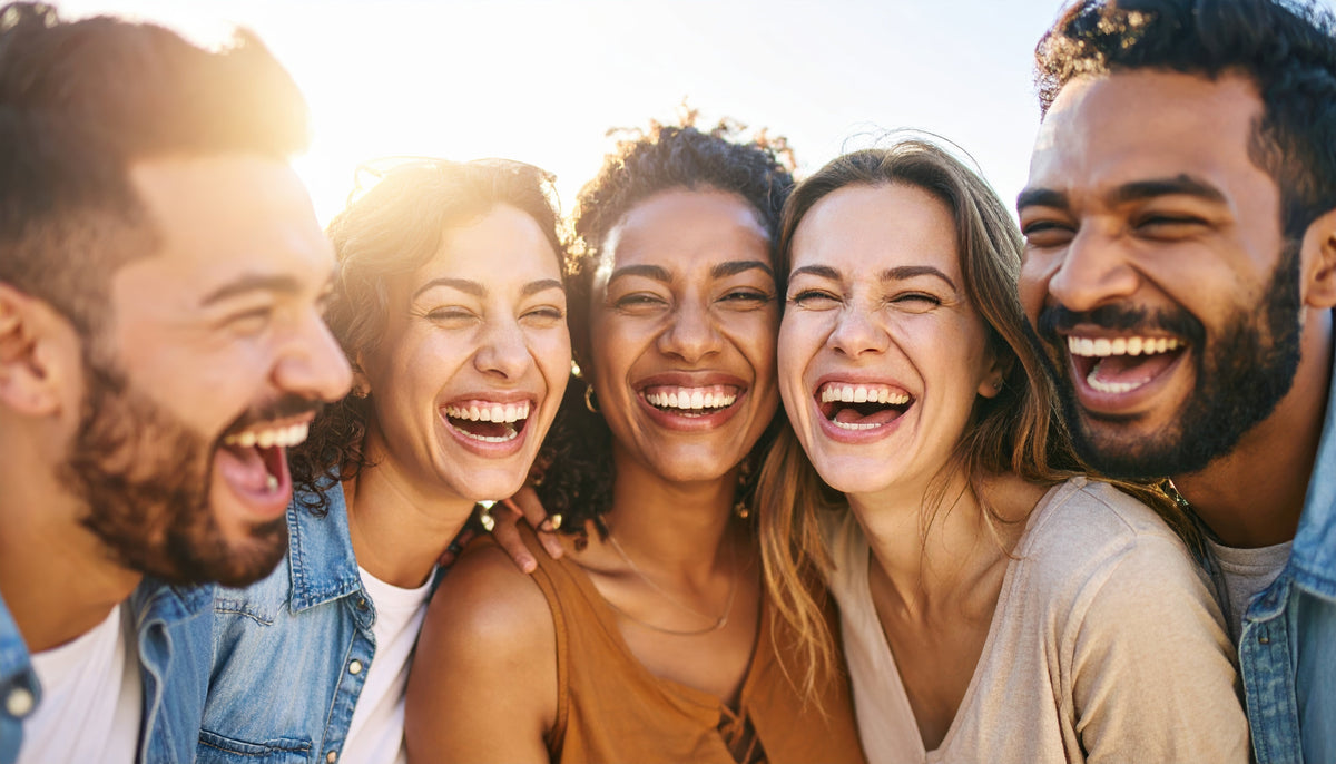 Grupo de amigos riéndose juntos al sol